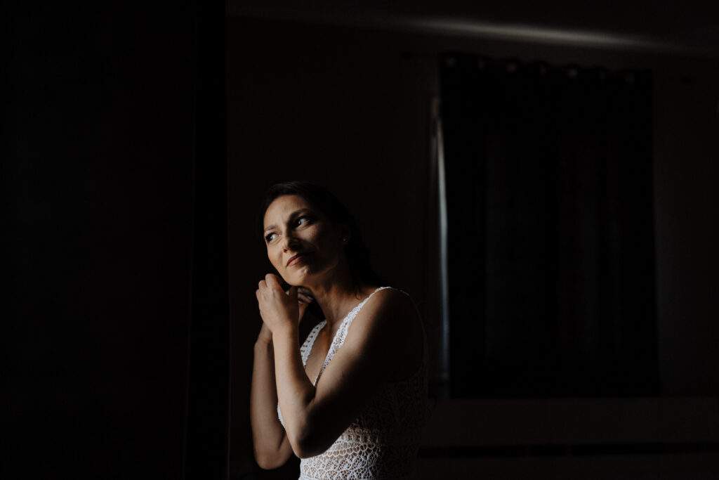 Ritratto di una donna vicino a una finestra in una stanza in penombra