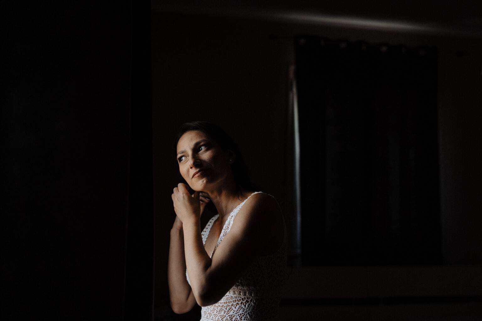 Ritratto di una donna vicino a una finestra in una stanza in penombra