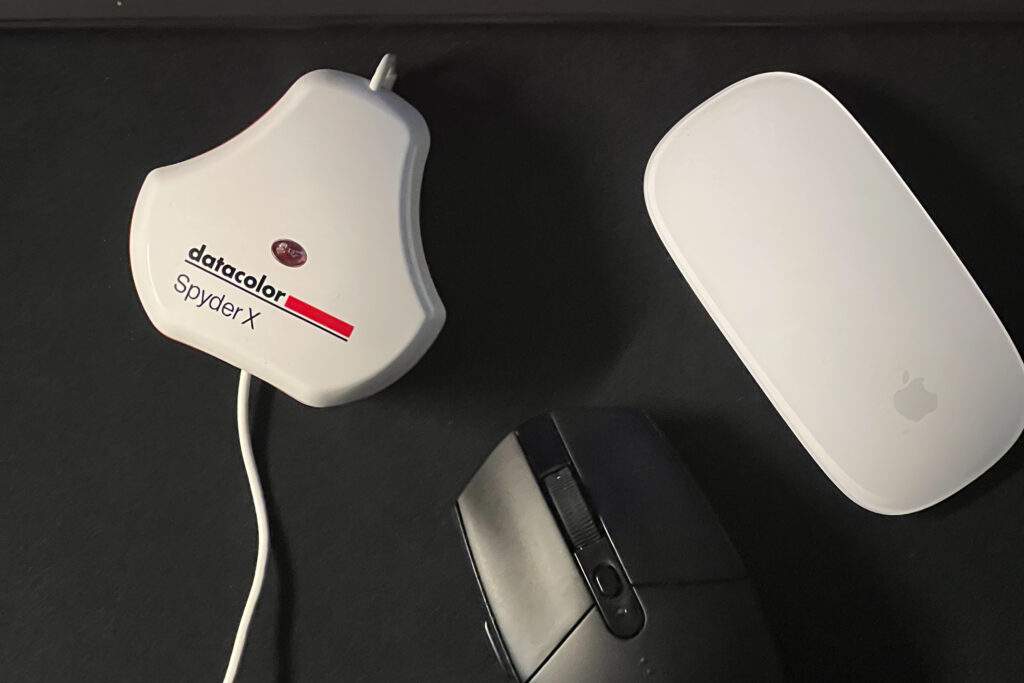 Calibratore per monitor e mouse su una scrivania scura